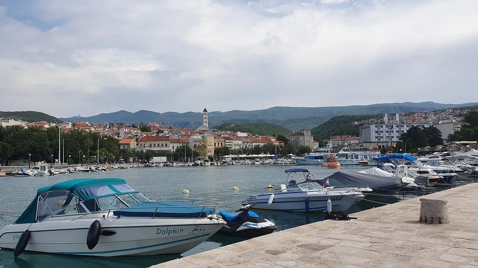 Local boats in Crikvenica harbour with the town and church tower beyond