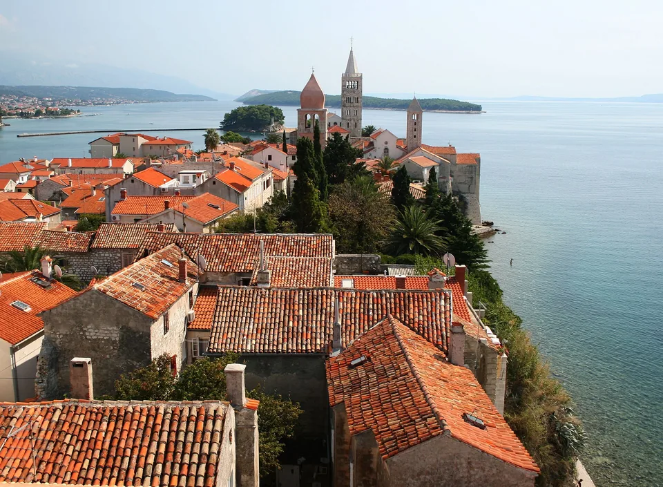 Red rooftops and church towers of Rab’s old town beside the Adriatic